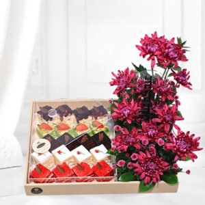 assorted mini cakes arranged with beautiful chrysantemum both sit on luxurios leather tray